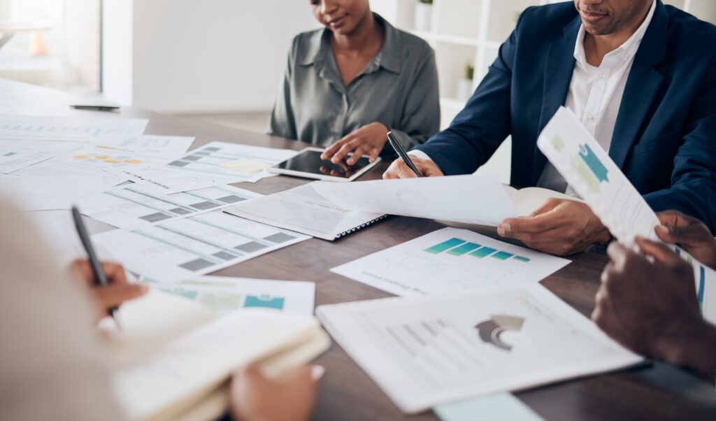 Business team reviewing sales reports and charts at a meeting table.